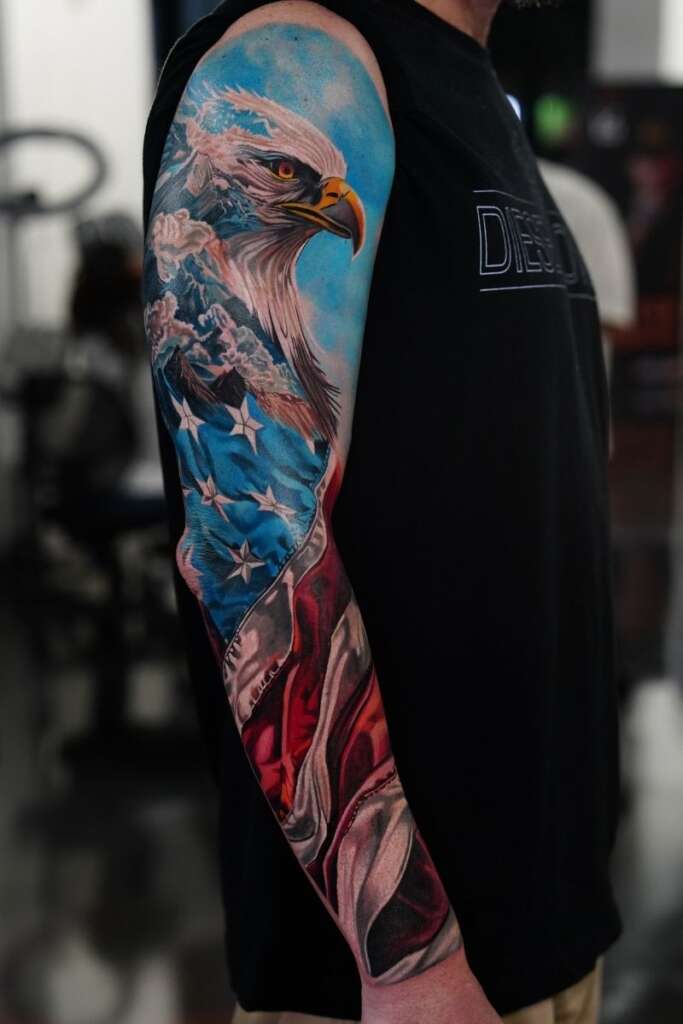 Color sleeve tattoo featuring a bald eagle and an American flag by Frank Tattoo Arts in Kansas City