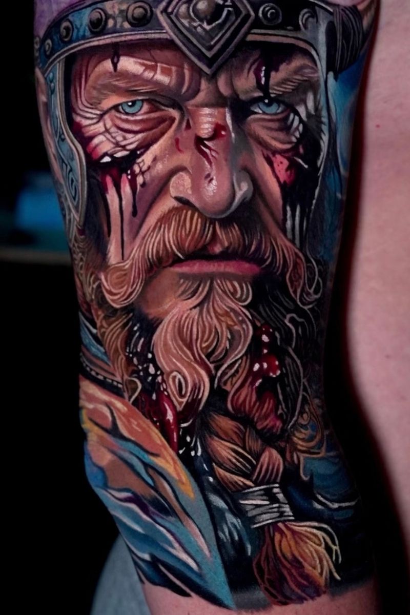 Color portrait tattoo of a Viking warrior with a braided beard and ornate helmet by Frank Tattoo Arts